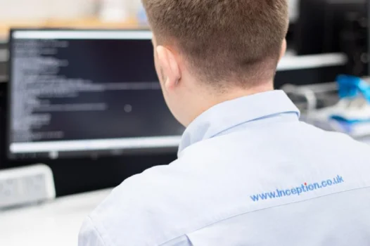 man using computer whilst taking call via headset