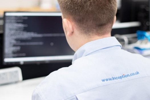 man using computer whilst taking call via headset