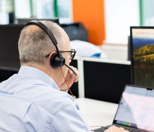 man using laptop wearing headset