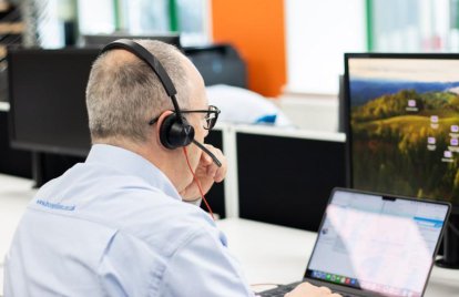 man using laptop wearing headset