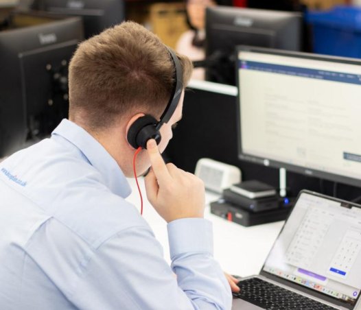 man using laptop wearing headset