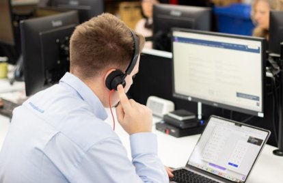 man using laptop wearing headset